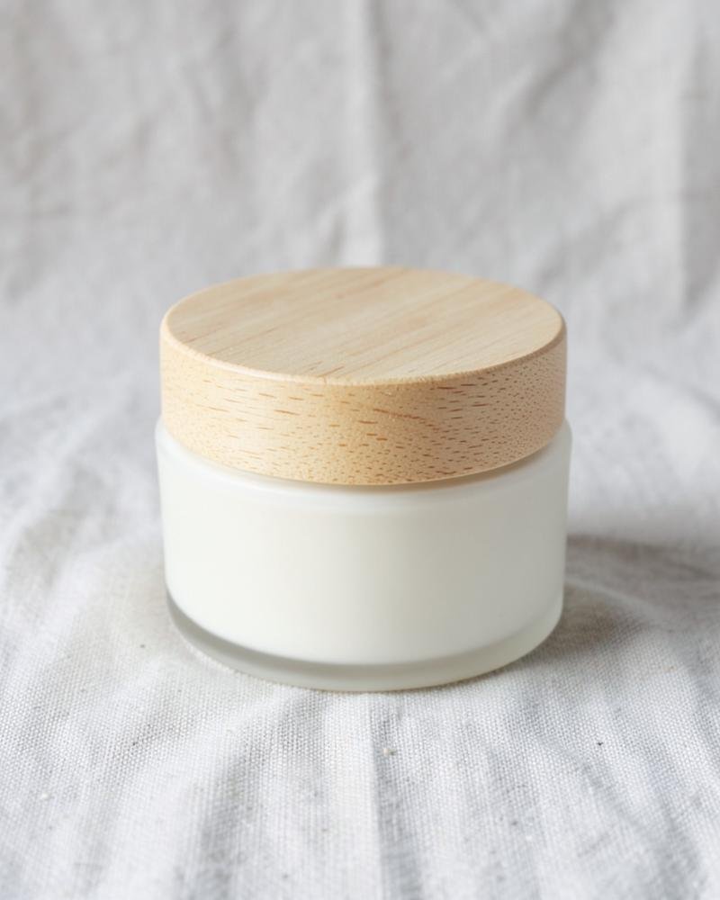 Matte cream jar with a light wooden lid on linen
